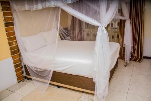 a bedroom with a bed with mosquito netting at Rugems Executive Lodge in Lusaka