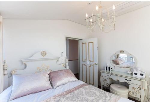 a bedroom with a white bed and a chandelier at HANI Haus in Jeju