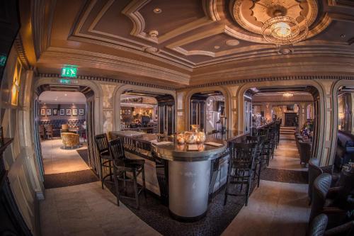 a bar in a restaurant with chairs and a ceiling at Me & Mrs Jones in Portstewart