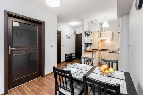 a kitchen and dining room with a table with a bowl of fruit at Apartament Gemini in Dzierżoniów