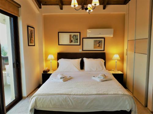 a bedroom with a large bed with two towels on it at Mountain Chalet Livadi in Arachova