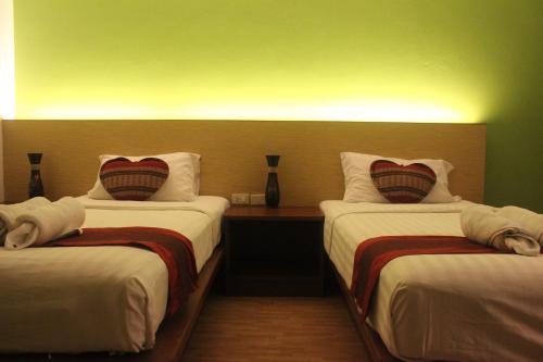 a hotel room with two beds with white sheets at Freedom Kata in Kata Beach