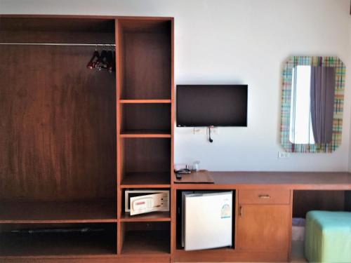 a living room with a tv and a wooden book shelf at Freedom Kata in Kata Beach