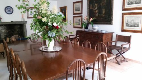 a dining room with a wooden table with a vase of flowers at Hotel Soazza in Soazza