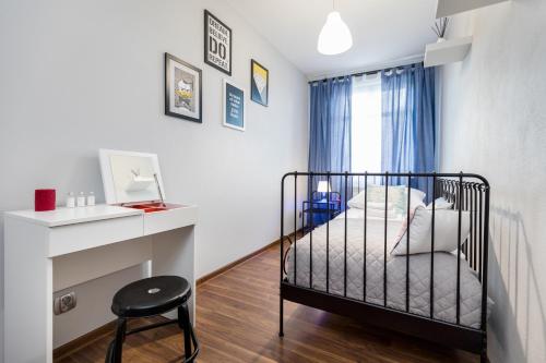 a small bedroom with a bed and a desk at Apartament Gemini in Dzierżoniów