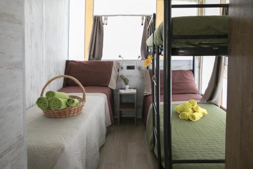 a bedroom with two bunk beds with a basket and stuffed animals at Ciriga Sicily Glamping in Santa Maria Del Focallo