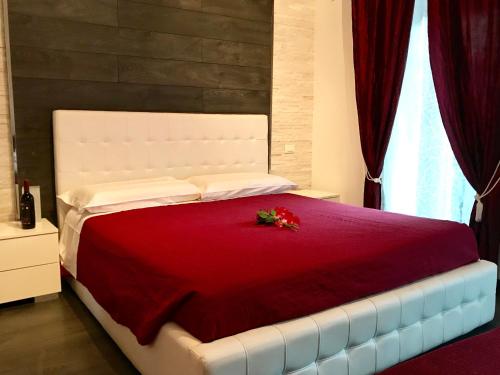 a bedroom with a red bed with a red flower on it at Royal Rooms in Rome