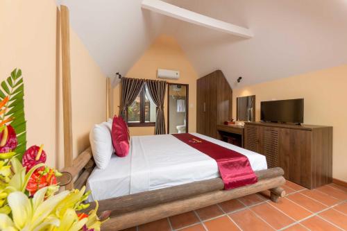 1 dormitorio con 1 cama y TV en La Paloma Resort, en Phu Quoc