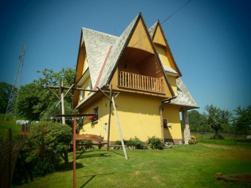 una casa con techo de gambrel y balcón en U Haliny - Blisko Term & Gorącego Potoku en Szaflary