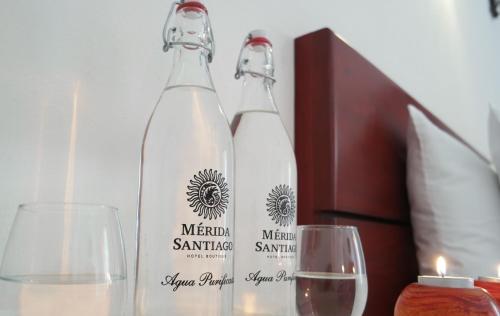 two bottles of wine and two glasses on a table at Merida Santiago Hotel Boutique in Mérida