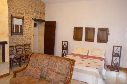 a bedroom with a bed and a chair in it at Le Lavoir de Meziat in Vinzelles