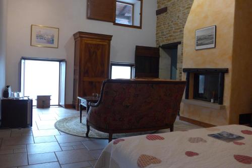 a bedroom with a bed and a chair in a room at Le Lavoir de Meziat in Vinzelles