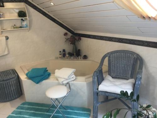 a bathroom with a bath tub and a chair at Ruhe geniessen bei Kulbes in Doberschütz