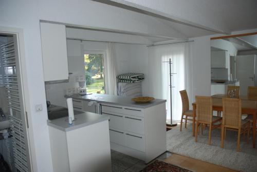 a kitchen with white cabinets and a table with chairs at Das grüne Häusle in Osterholz-Scharmbeck