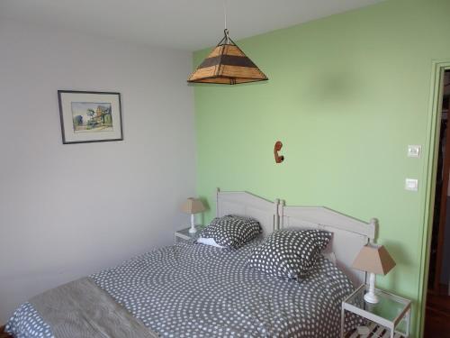 a bedroom with a bed with two pillows and a lamp at Roch'ar piguet in Carantec