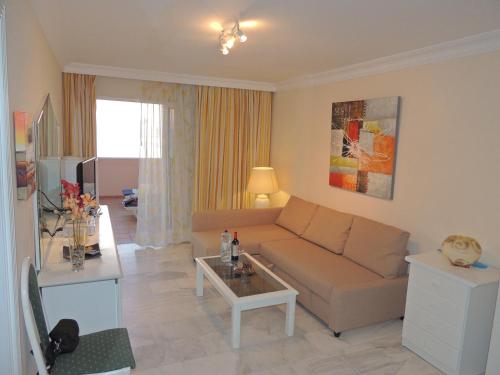 a living room with a couch and a table at Romantic Retreat with Marine View in Acantilado de los Gigantes