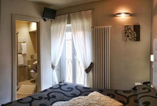 1 dormitorio con 1 cama y puerta al baño en Locanda di Orta en Orta San Giulio