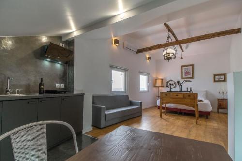 a kitchen and living room with a couch and a table at Memórias Charme Residences in Covilhã