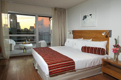 a bedroom with a large bed and a large window at BA Sohotel in Buenos Aires