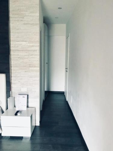 a hallway with a white wall and a white table at Royal Rooms in Rome