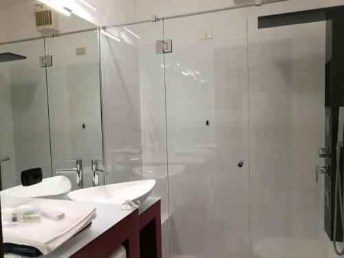 W łazience znajduje się szklana kabina prysznicowa i umywalka. w obiekcie Casa Carducci w mieście Turate