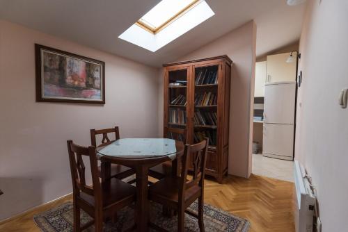 a dining room with a table and chairs and a refrigerator at Villa Fortuna in Mostar