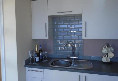 uma cozinha com um lavatório e uma parede de tijolos em Beach Cottage em Berwick-Upon-Tweed