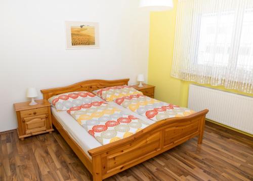 a bedroom with a wooden bed with pillows on it at Appartementhaus Thermeneck in Laa an der Thaya