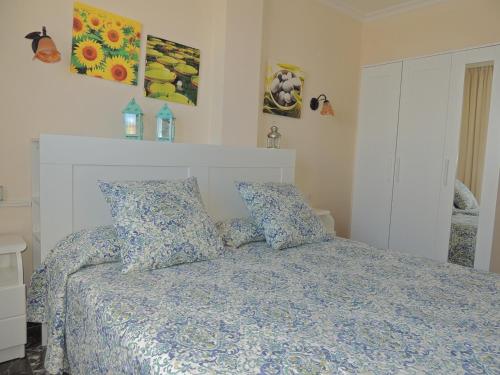 a bedroom with a bed with blue sheets and pillows at Magical Apt. with Sea View & Cliff in Acantilado de los Gigantes