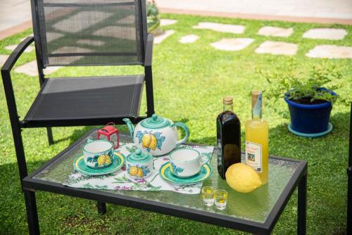 una mesa con set de té y una botella de vino en casa vacanza sole, en Tramonti