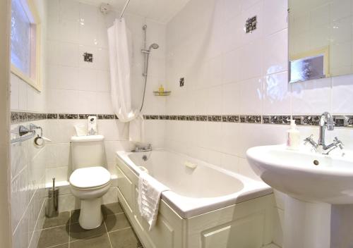uma casa de banho com um WC, um lavatório e uma banheira em Brook House Inn em Eskdale
