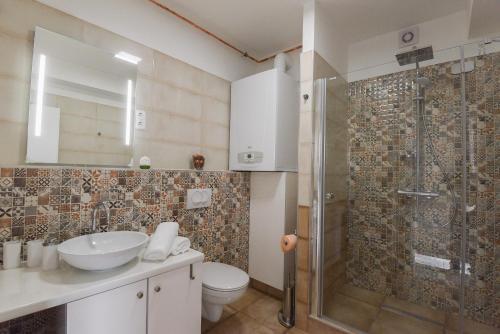 エゲルにあるVitalis Apartmanのバスルーム(シャワー、洗面台、トイレ付)