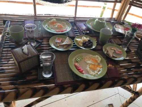een tafel met daarop borden met eten bij The Orchid Resort & Relax in Maha Sarakham