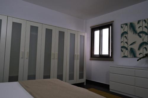 a bedroom with white closets and a window at Apartamento Sauco in Los Llanos de Aridane