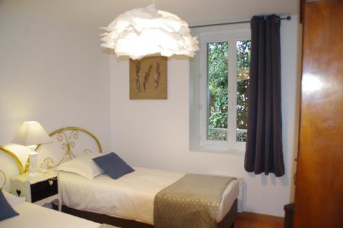 a bedroom with two beds and a window at La Cour Royale in Bayeux