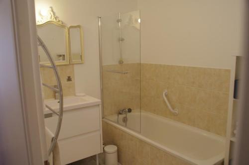 a bathroom with a shower and a tub and a sink at La Cour Royale in Bayeux
