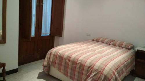 1 dormitorio con 1 cama con edredón a rayas en Calle Herbolarios, en Sevilla