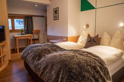 sypialnia z dużym łóżkiem z kocem w obiekcie Appartement Mühle w Kaprunie