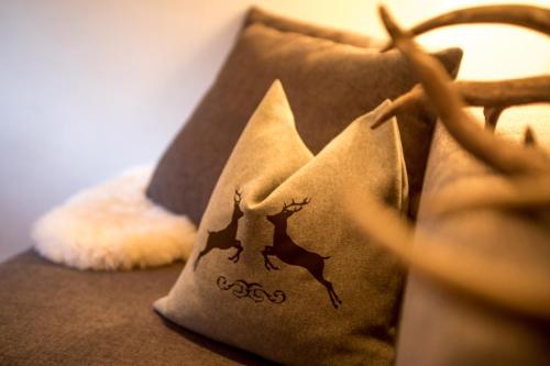 a pillow with deer on it sitting on a couch at Appartement Mühle - including Summercard, Sauna, Kaprun's largest private garden with panoramic view in Kaprun