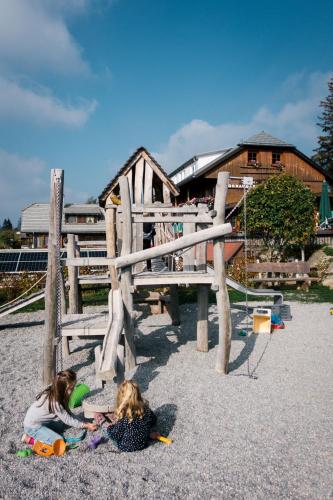 two little girls playing in the sand in a playground at Höhengasthaus Kolmenhof an der Donauquelle in Furtwangen