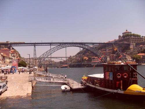 a boat on a body of water near a bridge at Gran Cruz House in Porto