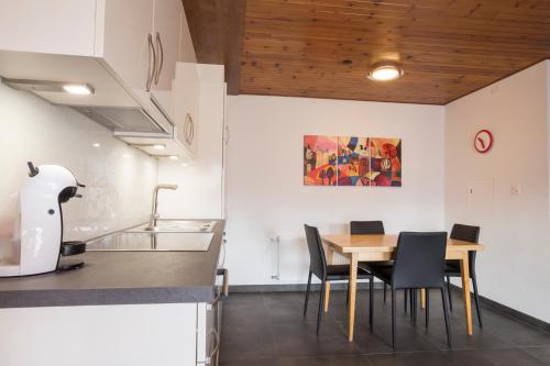 a kitchen and dining room with a table and chairs at Immeuble Horizon in Les Collons