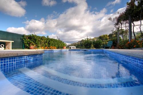a large swimming pool with blue tiles on the sides at Casa Velha in Paradamonte