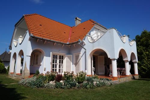 バラトンケレストゥールにあるTieff Apartmanház Balatonmáriafürdő Hullámtelepのオレンジ色の屋根の白い家