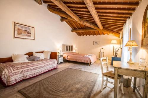 1 Schlafzimmer mit 2 Betten und einem Schreibtisch in einem Zimmer in der Unterkunft Agriturismo Podere il Palagio in Fiesole