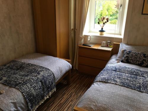 A bed or beds in a room at Dalmore Lodge Guest House