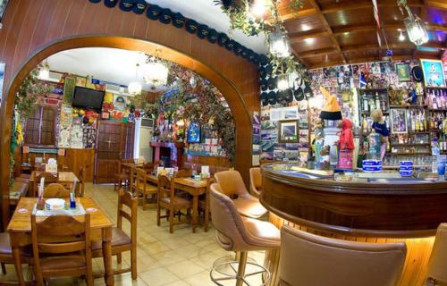 a restaurant with a bar and tables and chairs at Stavros Pension in Rhodes Town
