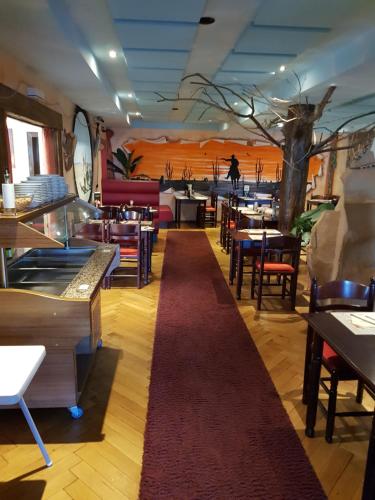 ein Restaurant mit Tischen und Stühlen und einem roten Teppich in der Unterkunft Desperados Hotel in Bergen