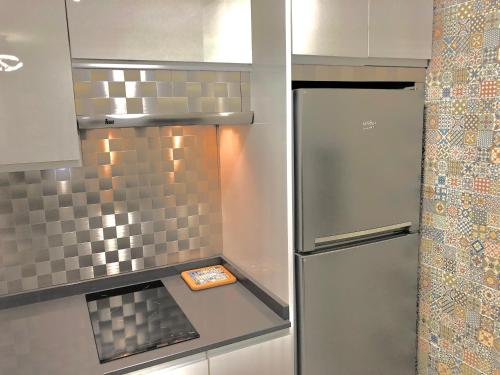 a small kitchen with a stainless steel refrigerator at W W W GoyaHospitales es Bajo B in León