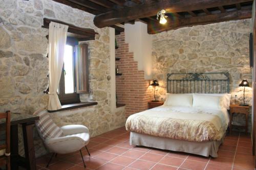 a bedroom with a bed and a chair at Posada Puerta Grande in Candelario
